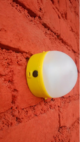 Soul Light hanging on a red brick wall