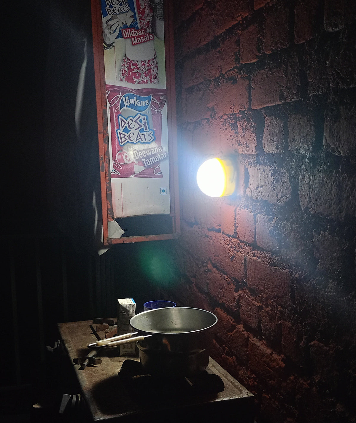Dark room with Soul Light hanging from the ceiling, illuminating the kitchen.
